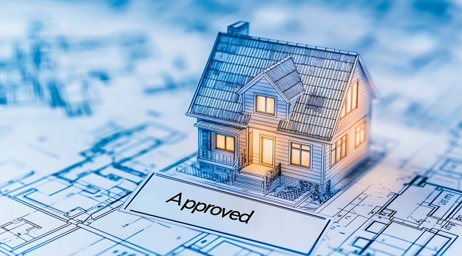 Architectural blueprint and house model representing successful planning stage odour assessment