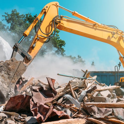 Demolition of building. Excavator breaks old house. Freeing up space for construction of new building